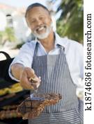 Man Barbequing In A Garden Man Barbequing In A Garden