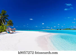 Palm trees over lagoon and white sandy beach