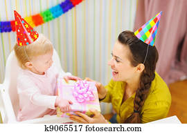 Mother giving birthday gift for baby