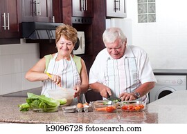 elderly couple cooking in home kitchen elderly couple cooking in home kitchen