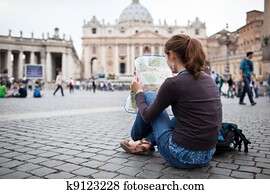 Pretty young female tourist studying a map at St. Peter's square in the Vatican City in Rome Pretty young female tourist studying a map at St. Peter's square in the Vatican City in Rome