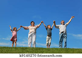 grandchildren and their grandparents standing on lawn and holding for reared hands