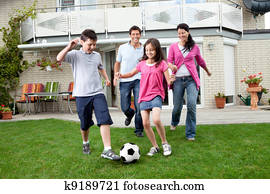 Happy family playing football in their backyard Happy family playing football in their backyard