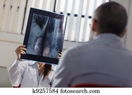 Female doctor working in hospital with patient and x-rays