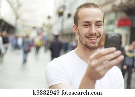 Young Man with cell phone walking