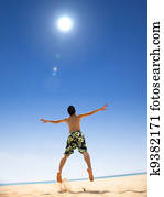 happy young man jumping on the beach