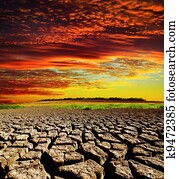 red dramatic sunset over dry cracked earth