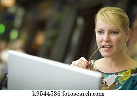 Beautiful Blonde Woman Using Her Laptop Computer in the City Lights.