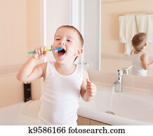 Boy cleaning teeth in bathroom Boy cleaning teeth in bathroom