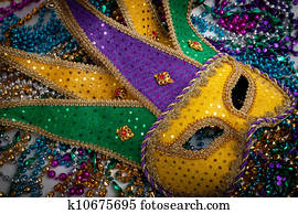 A yellow Mardi Gras mask and beads A yellow Mardi Gras mask and beads
