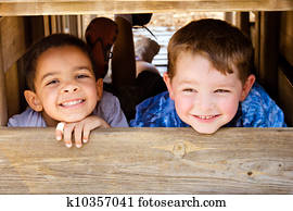 African-American child and caucasian child playing together on playground African-American child and caucasian child playing together on playground