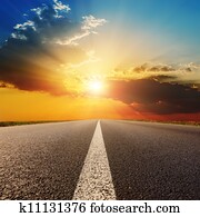 asphalt road under sunset with clouds