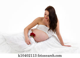 Beautiful pregnant brunette lady on white background
