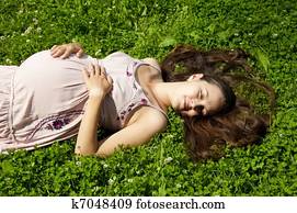 Beautiful pregnant woman relaxing in the park