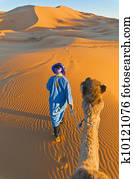 Berber walking with camel at Erg Chebbi, Morocco