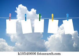 Blank photos hanging on a clothesline, blue sky on background
