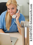 Blonde nurse calling while looking at camera