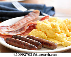 breakfast meal with sausage and scrambled eggs with bacon. breakfast meal with sausage and scrambled eggs with bacon.