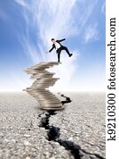 busines and Economic crisis concept. cracked road and unstable businessman on the money tower
