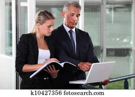 Businessman and young assistant rushing to prepare presentation