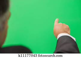 Businessman pointing to green copy space