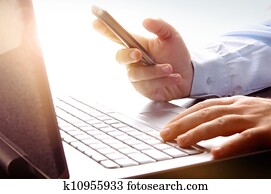 Businessman using laptop and phone