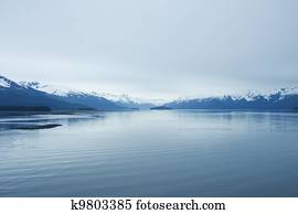 Calm Water and Mountains in Blue Light of Dawn