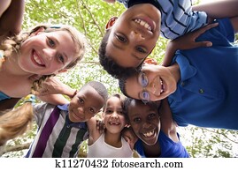 Children embracing in circle around the camera and smiling