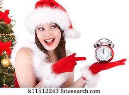 Christmas woman in santa hat and fir tree with alarm clock.
