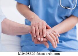 Close up of a nurse touching hand of a patient