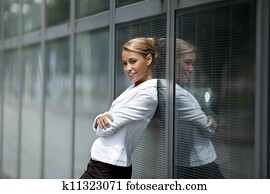 confident woman leaning on office building window