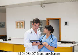 Doctor holding a tablet computer next to a nurse