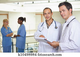 Doctors looking at camera next to nurses
