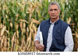 Farmer in a field with a laptop computer Farmer in a field with a laptop computer