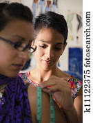 Fashion designer using measuring tape with client