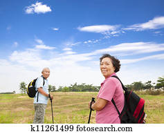 happy asian senior couple hiking in the nature