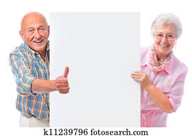 happy smiling senior couple with a blank board