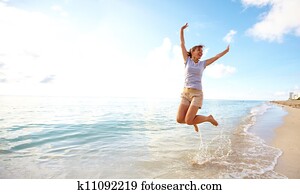 Happy woman jumping on the beach. Happy woman jumping on the beach.