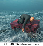 Man afloat on desk in sea of currency