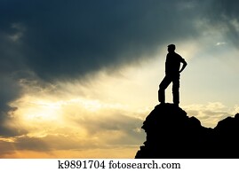 Man on peak of mountain.