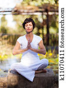 middle aged woman doing meditation 
