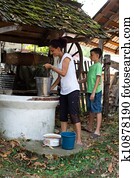 Mother and son getting water from well
