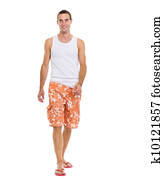 On vacation smiling young man in shorts walking