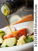 pouring olive oil over salad pouring olive oil over salad