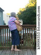 Senior Woman Holding Puppy Vertical