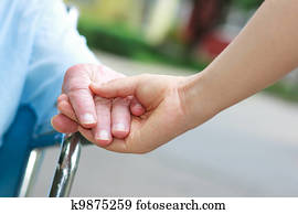 Senior women in wheelchair holding hands