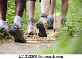 shoes of people trekking in wood and walking in row shoes of people trekking in wood and walking in row