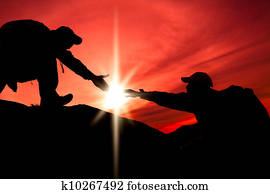 Silhouette of helping hand between two climber Silhouette of helping hand between two climber