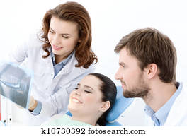The patient examines the x ray photo of her teeth