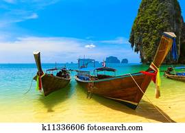 Travel landscape, beach with blue water and sky at summer. Thailand nature beautiful island and traditional wooden boat. Scenery tropical paradise resort. Travel landscape, beach with blue water and sky at summer. Thailand nature beautiful island and traditional wooden boat. Scenery tropical paradise resort.